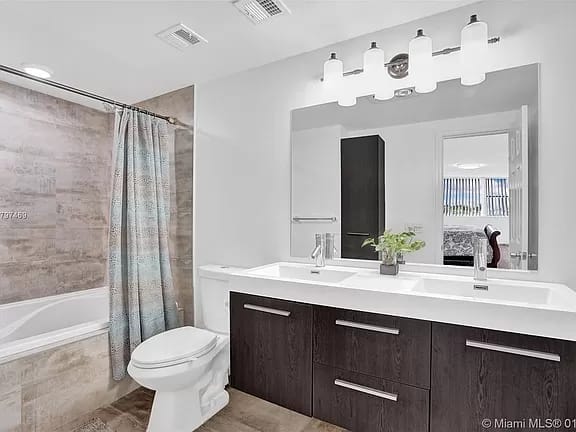 Bathroom renovation with a double vanity and modern lighting