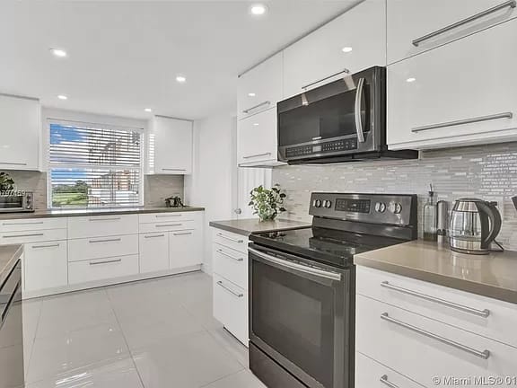 Modern white kitchen with stainless steel appliances