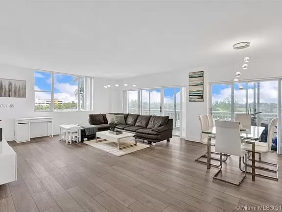 Renovated living room with large windows and wood-look flooring